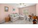 Bedroom featuring a light pink color scheme, sofa, ceiling fan, and natural lighting at 8352 Se 168Th Trinity Pl, The Villages, FL 32162