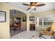Cozy living room open to dining room area, featuring a ceiling fan, electric fireplace, and large window at 8352 Se 168Th Trinity Pl, The Villages, FL 32162