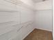 Walk-in closet featuring wall-mounted white wire shelving and brown carpeted floor at 8463 Sw 108Th Ln, Ocala, FL 34481