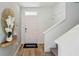 Bright foyer with wood-look floors, a staircase and decorative gold sunburst mirror at 8647 Sw 44Th Ter, Ocala, FL 34476
