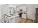 Modern kitchen with a view of the backyard features stainless appliances and a large island with seating at 8647 Sw 44Th Ter, Ocala, FL 34476