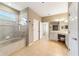 Bright bathroom featuring a tiled shower-tub, double vanity, and tiled floors at 8650 Sw 83Rd Loop, Ocala, FL 34481