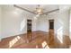 Large primary bedroom with laminate floors, a trey ceiling, ceiling fan, and access to a walk-in closet at 8650 Sw 83Rd Loop, Ocala, FL 34481