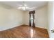 Bedroom with hardwood floors, fan, and a window with decorative curtains at 8650 Sw 83Rd Loop, Ocala, FL 34481