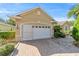 Well-kept garage with a modern door, brick-paved driveway, and neatly trimmed shrubs at 8650 Sw 83Rd Loop, Ocala, FL 34481