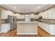 This spacious kitchen features white cabinets, stainless steel appliances, a center island, and granite countertops at 8650 Sw 83Rd Loop, Ocala, FL 34481