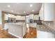 Bright kitchen features white cabinets, granite countertops, stainless steel appliances, and an island with seating at 8650 Sw 83Rd Loop, Ocala, FL 34481