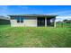 Residential backyard featuring a screened-in lanai, a window, and green grass at 8870 Sw 62Nd Ave, Ocala, FL 34476