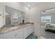 Main bathroom featuring double sinks with granite countertops, white cabinets, a large mirror, and shower at 8870 Sw 62Nd Ave, Ocala, FL 34476