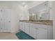 Main bathroom featuring double sinks with granite countertops, white cabinets, and a large mirror at 8870 Sw 62Nd Ave, Ocala, FL 34476