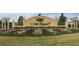 Landscaped community entrance sign with mature trees and colorful flowers at 8870 Sw 62Nd Ave, Ocala, FL 34476