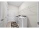 Bright laundry room features a washer, dryer, storage shelves and a door to the outside at 8870 Sw 62Nd Ave, Ocala, FL 34476
