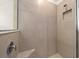 Shower featuring beige tile, a shower head, a ledge, and a glass door at 8870 Sw 62Nd Ave, Ocala, FL 34476