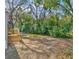 Spacious backyard with a wooden deck, lush trees, and plenty of space to add your personal touches at 9100 Sw 32Nd Ct, Ocala, FL 34476