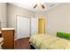Cozy bedroom features a ceiling fan, closet, and a comfortable bed with a colorful painting at 9628 Sw 90Th St, Ocala, FL 34481