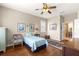 Inviting bedroom with hardwood floors, ceiling fan, and large window view at 9628 Sw 90Th St, Ocala, FL 34481