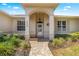 Inviting front porch with decorative columns, brick pathway and lush landscaping at 9628 Sw 90Th St, Ocala, FL 34481