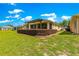 Exterior of home featuring an expansive lush green backyard and covered patio area at 9642 Sw 95Th Loop, Ocala, FL 34481