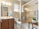 Bright bathroom featuring a glass shower, modern vanity, toilet, and neutral tile floors at 9642 Sw 95Th Loop, Ocala, FL 34481