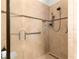 Modern tiled shower featuring sleek fixtures, grab bar, and seamless glass door at 9642 Sw 95Th Loop, Ocala, FL 34481