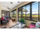 Relaxing sunroom with ceiling fan and views of the landscaped backyard and lush greenery at 9642 Sw 95Th Loop, Ocala, FL 34481