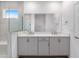 Bright bathroom featuring a double sink vanity with a quartz countertop and a glass-enclosed shower at 10427 Sw 98Th Place Rd, Ocala, FL 34481
