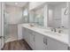 Bright bathroom featuring a double sink vanity with a quartz countertop and a glass-enclosed shower at 10427 Sw 98Th Place Rd, Ocala, FL 34481