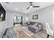 Living area has a grey sofa, glass table and screened in patio with ceiling fan at 10427 Sw 98Th Place Rd, Ocala, FL 34481
