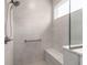 Walk-in shower featuring white tiling, a built-in seat, a hand-held shower head, and a safety bar at 10427 Sw 98Th Place Rd, Ocala, FL 34481