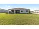Spacious backyard provides ample space for relaxation and recreation with a view of the home's exterior at 10569 Sw 98Th Pl, Ocala, FL 34481