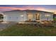 Charming single-story home with manicured lawn, paver driveway, and inviting front entrance at sunset at 10569 Sw 98Th Pl, Ocala, FL 34481
