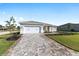 Charming single-story home with manicured lawn, long paver driveway, and inviting front entrance at 10569 Sw 98Th Pl, Ocala, FL 34481