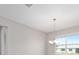 Bright living room showcasing a chandelier, large window, and neutral walls, creating a welcoming space at 10569 Sw 98Th Pl, Ocala, FL 34481