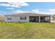 This backyard features a screened in patio, lush green grass, and landscaping at 10976 Sw 101St Loop, Ocala, FL 34481