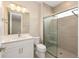 Modern bathroom featuring tile shower, glass doors, quartz countertop, and white cabinetry at 10976 Sw 101St Loop, Ocala, FL 34481
