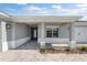 Inviting covered entrance showcasing a paved walkway, neutral columns, and elegant front door at 10976 Sw 101St Loop, Ocala, FL 34481