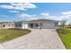 Beautiful single-story home featuring a paved driveway, neutral paint, and a well-maintained lawn on a sunny day at 10976 Sw 101St Loop, Ocala, FL 34481