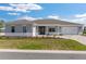 Charming single-story home featuring a manicured lawn, neutral colors, and paved driveway on a sunny day at 10976 Sw 101St Loop, Ocala, FL 34481