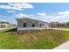 Attractive single-story home displaying a green lawn and paved driveway on a clear day at 10976 Sw 101St Loop, Ocala, FL 34481