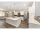 Modern kitchen with a large island, stainless steel appliances, white cabinetry, and stylish pendant lights at 10976 Sw 101St Loop, Ocala, FL 34481