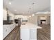 Modern kitchen boasting stainless steel appliances, white cabinetry, gray backsplash, and a large island with quartz countertops at 10976 Sw 101St Loop, Ocala, FL 34481