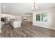 Open kitchen and dining area with stainless appliances, a large island, and wood-look flooring at 10976 Sw 101St Loop, Ocala, FL 34481