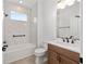 Modern bathroom featuring marble tiled shower and wood vanity with black fixtures at 10977 Sw 101St Loop, Ocala, FL 34481