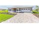 Beautiful single-story home with a brick paver driveway and lush green lawn at 10977 Sw 101St Loop, Ocala, FL 34481