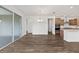 Wood-look floors throughout a bright living area with sliding glass doors, a dining chandelier, and open flow to kitchen at 10977 Sw 101St Loop, Ocala, FL 34481