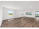 Bright living area with wood-look floors, large windows and adjacent view of an outdoor patio at 10977 Sw 101St Loop, Ocala, FL 34481