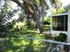 Private backyard featuring a screened lanai, mature trees, lush landscaping, and fenced perimeter at 13762 Sw 112Th Ter, Dunnellon, FL 34432