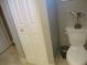 A small bathroom with a white toilet, closet, and bird figurine accentuates the minimalist space at 13762 Sw 112Th Ter, Dunnellon, FL 34432