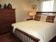 Relaxing bedroom with wooden bed frame, a dresser, a decorative wall hanging and two bedside lamps at 13762 Sw 112Th Ter, Dunnellon, FL 34432