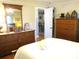 Comfortable bedroom with hardwood floors, a large dresser, and an open doorway to another room at 13762 Sw 112Th Ter, Dunnellon, FL 34432
